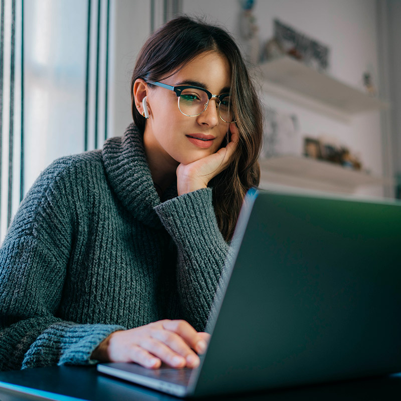 Mujer con audífonos mirando computador Mujer con audífonos mirando computador