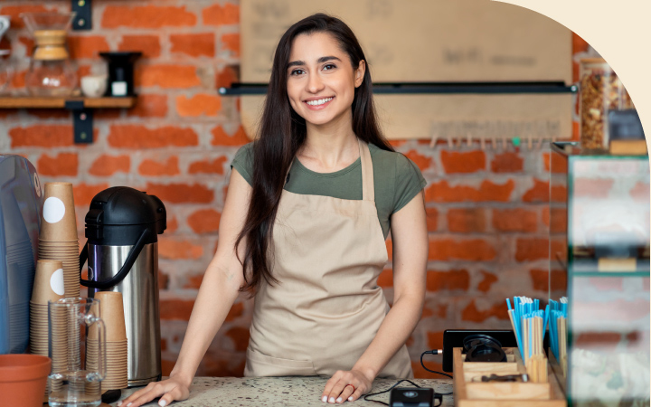 Mujer sonriendo posando en su local comercial