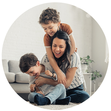 Mamá jugando con sus dos hijos en un sillón