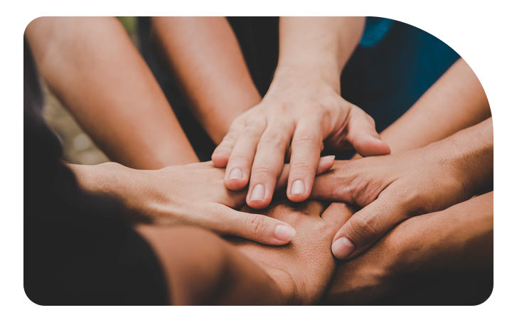 Grupo de personas juntando las manos