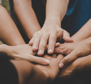 Grupo de personas juntando las manos
