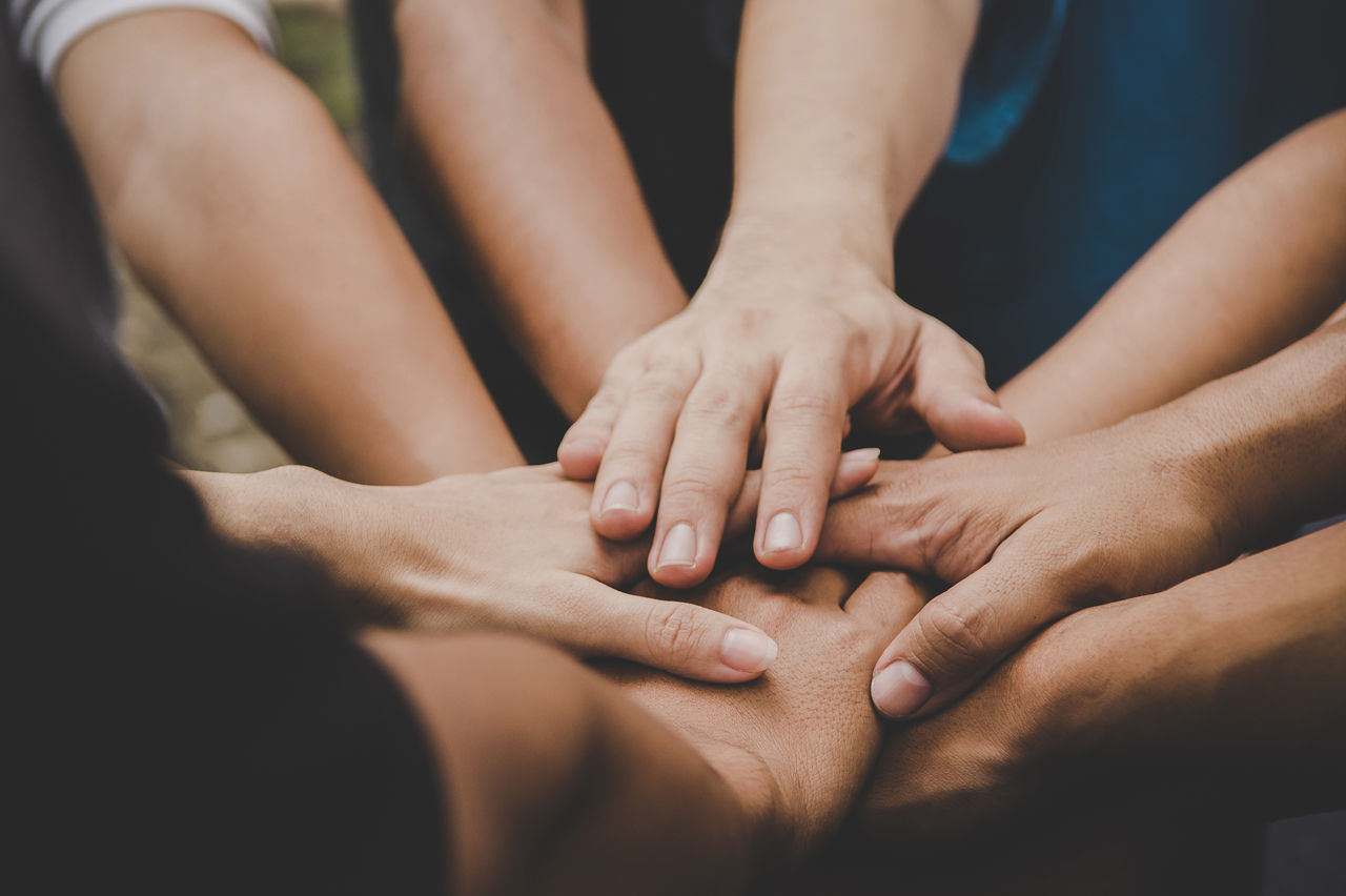 Grupo de personas juntando las manos