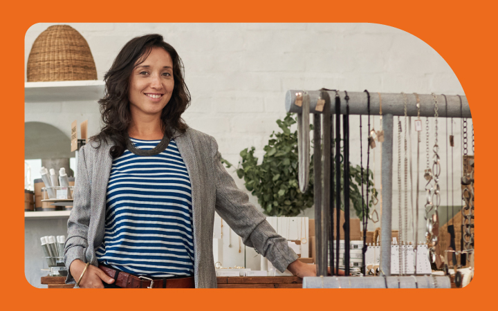 Mujer sonriendo posando en su local comercial